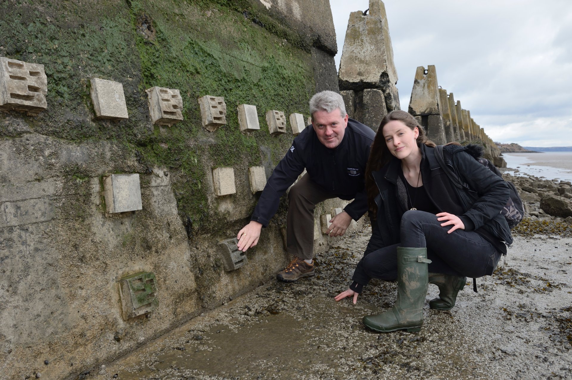 Dale Lyon Concrete in the Classroom) and Mairi MacArthur ( PhD student Glasgow Uni), standing beside some concrete habitat blocks installed on the sea defences at Cramond as part of the Concrete in the Classroom project. ©Lorne Gill/SNH